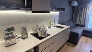 Eine moderne Küche mit Mikrowelle, Toaster, Wasserkocher und Töpfen auf der Arbeitsplatte.