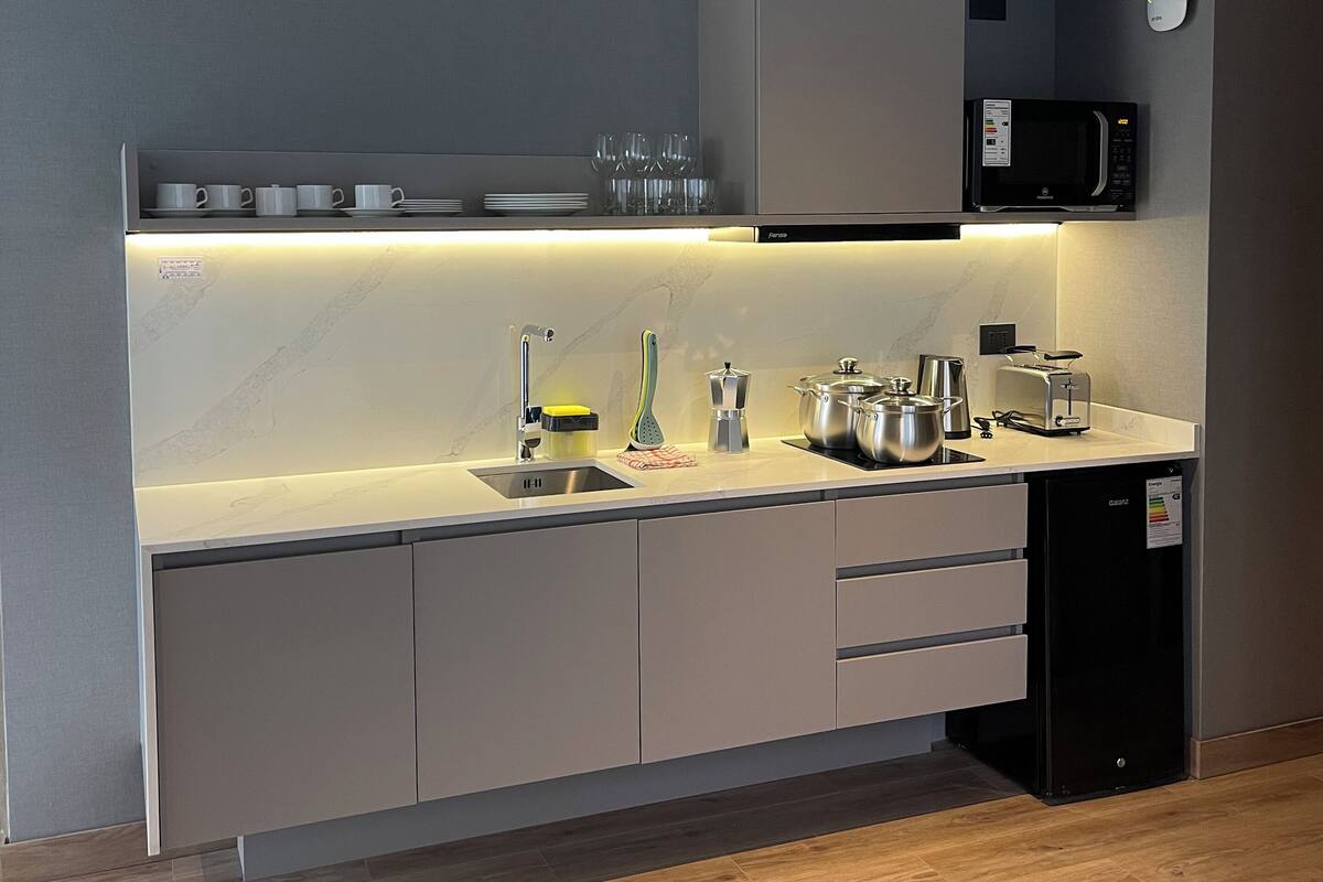 A modern kitchen with a built-in microwave, toaster, and kettle.