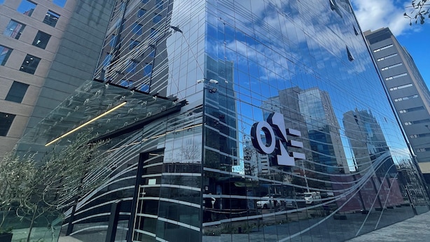 Ein modernes Glasgebäude mit einem gut sichtbaren Logo an der Fassade.