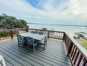 A wooden deck with a table and chairs, overlooking a body of water. - Fishing paradise!!! House on Livingston with private dock! (Trinity)