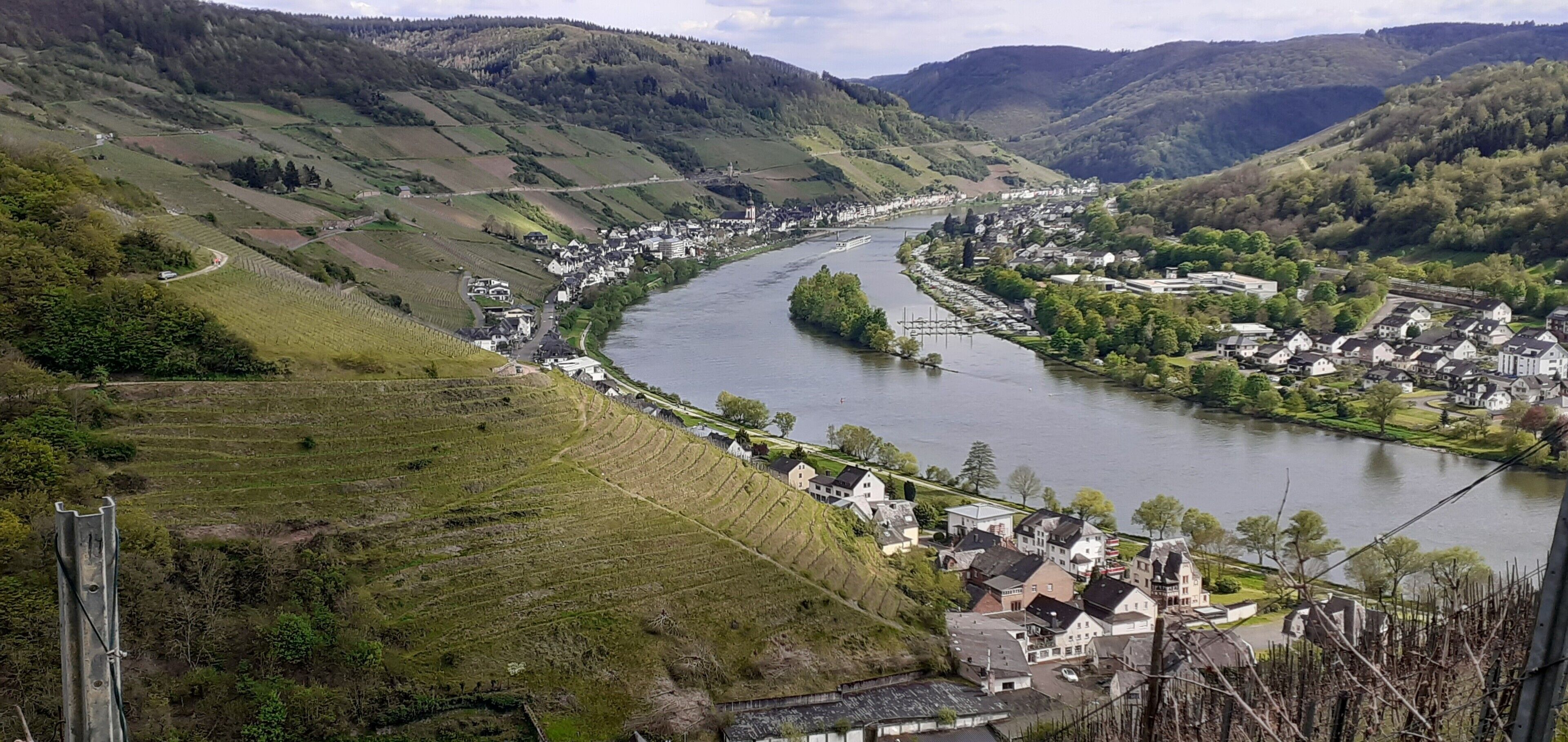 Une rivière qui traverse une vallée où se trouvent des maisons et des vignobles.