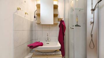 Ein Badezimmer mit Waschbecken, Spiegel und Dusche.