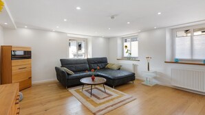 Ein stilvolles Wohnzimmer mit einer Couch, einem Couchtisch und einem Holzkabinett.