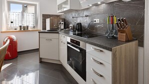 Eine moderne Küche mit Einbauofen, Kaffeemaschine und Messerblock.