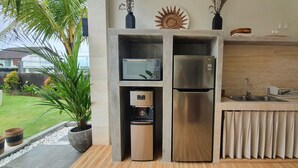 A compact kitchen with a built-in microwave, refrigerator, and sink.