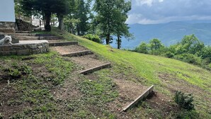 A stone staircase leading up a grassy hill with a dog resting on the steps. - Casa Rural Independiente en Asturias, Admitimos Mascotas (Llanuces)