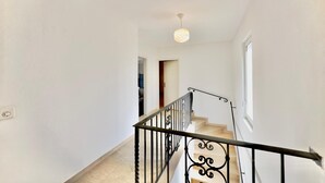 Una escalera con barandillas de hierro forjado negro que conduce a un rellano.