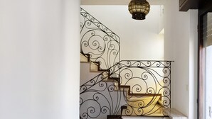 A staircase with ornate black metal railings and a light fixture above. - Mansarda Vialba Apartment in Holiday Home with Lake View and Balconies (Germignaga)