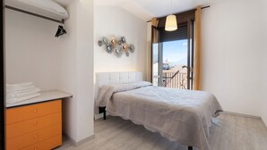 A bedroom with a bed, a wardrobe, a radiator, and a window with a view. - Mansarda Vialba Apartment in Holiday Home with Lake View and Balconies (Germignaga)