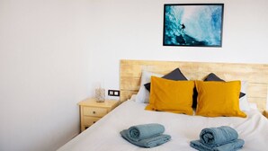 A bed with two rolled towels, a nightstand with a glass container, and a framed picture on the wall. - Holiday Villa 'Casa Jenabe' with Mountain Views, Private Terrace and Wi-Fi (la vegueta)