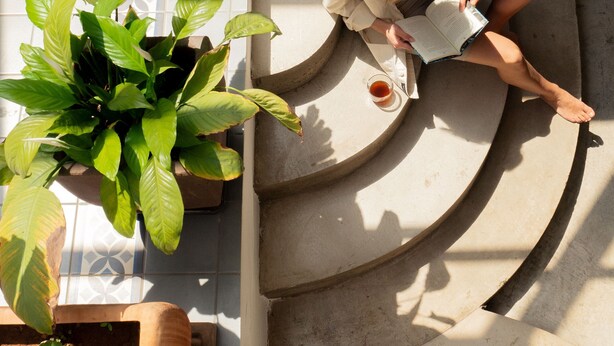 A person reading a book on a curved staircase with a potted plant beside them. - Holiday Villa 'Casa Jenabe' with Mountain Views, Private Terrace and Wi-Fi (la vegueta)