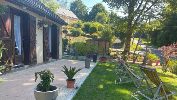 A well-maintained garden with a lawn, potted plants, and outdoor seating.