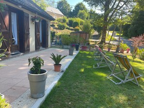 A well-maintained garden with a lawn, potted plants, and outdoor seating. - Lovely vacation home Maison du lac (Marcillac-la-Croisille)