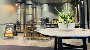 A modern interior with a round table, a decorative plant, and a signboard. - Southbank 2BR w/ Parking, Balcony & Pool – Walk to Crown (Southbank)