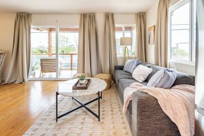 Relax in this inviting living room with a comfortable sofa, round coffee table, and large window.