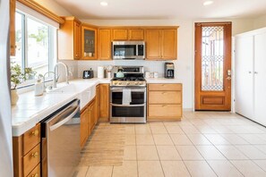 Kitchen features a sink, microwave, oven, and coffee maker.