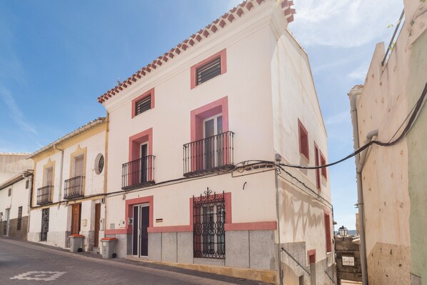 Un edificio con balcón, puerta y ventana.