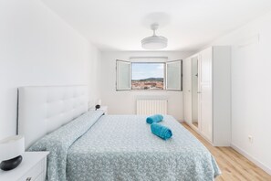 A bedroom with a bed, a window with a view, a ceiling fan, and a wardrobe. - Holiday Home 'Parraga' with Mountain View, Private Terrace and Balcony (Cehejín)