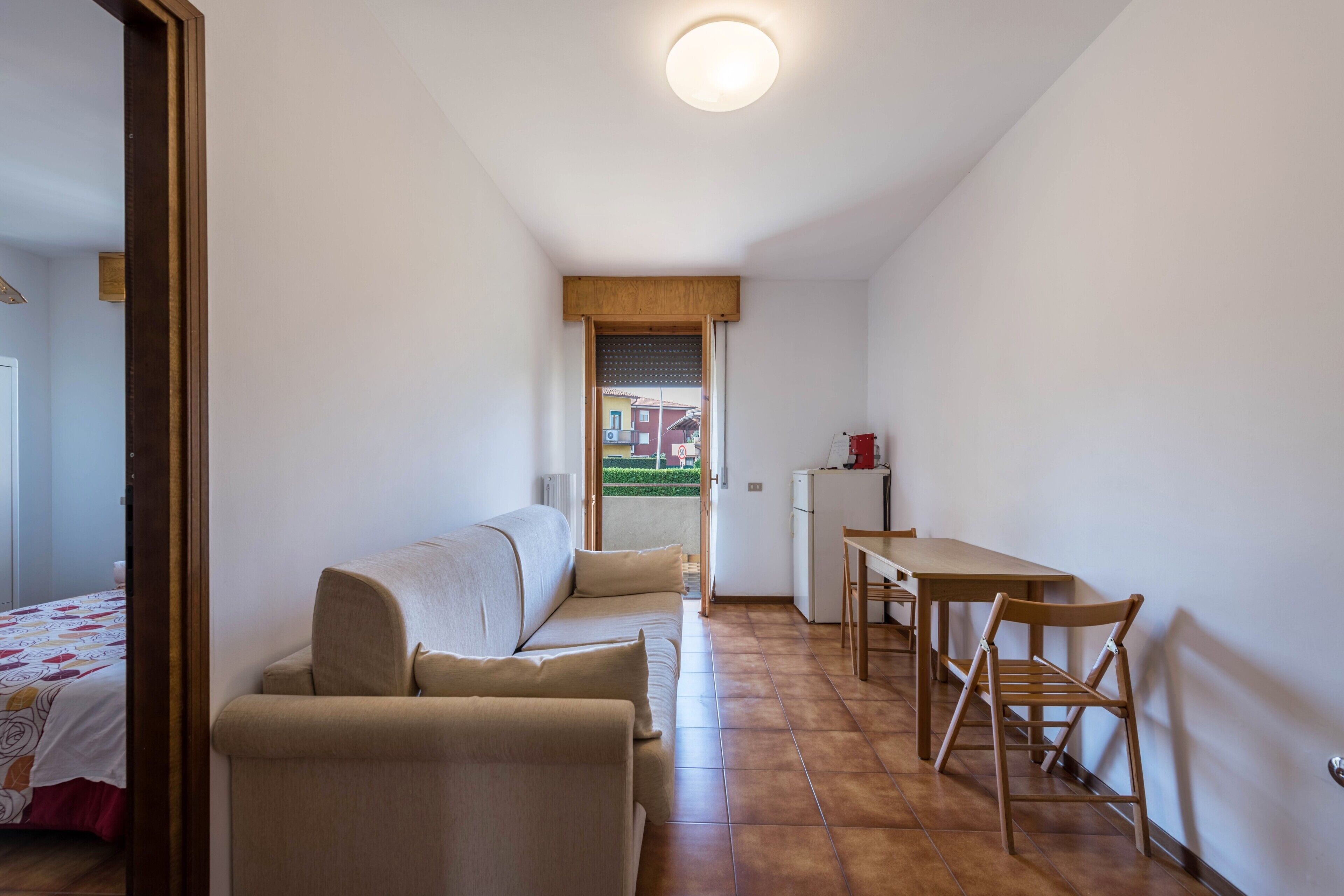 Une pièce de taille modeste, comprenant un canapé, une petite table et une chaise.