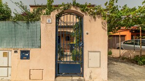 A building with a metal gate, a small door, and a number sign.