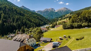 A rural village with houses, a playground, and a mountain backdrop. - Apartment "Perfila Dolomitenblick" with Mountain View, Shared Garden & Wi-Fi (Valdaora)