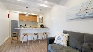 Une cuisine moderne avec des meubles en bois, un réfrigérateur en acier inoxydable et un coin bar avec des tabourets.