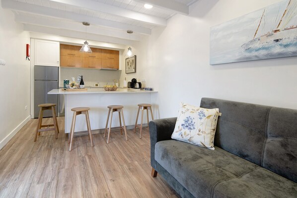 Une cuisine moderne avec des meubles en bois, un réfrigérateur en acier inoxydable et un coin bar avec des tabourets.