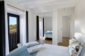 A hotel room with a bed, a view through a door, and a balcony. - Vacation Home "Adega Do Portinho Velho" with Balcony & Wi-Fi (Engrade)