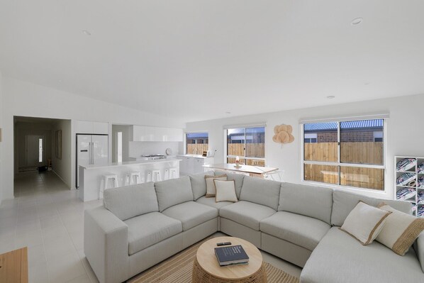Relax in this spacious living area with a large sofa, coffee table, and dining space.