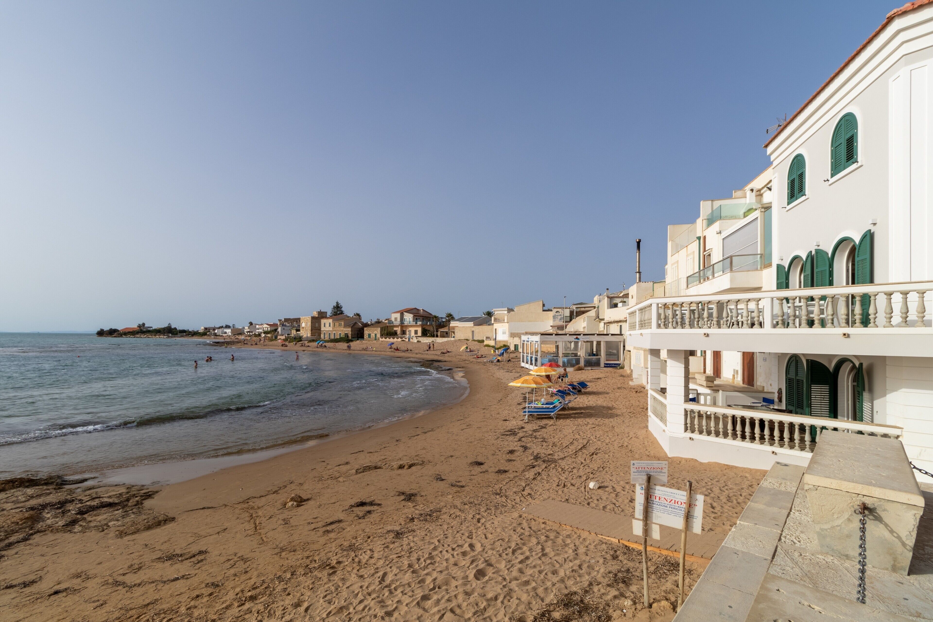 Ein Hotel direkt am Strand mit Balkon, Sandstrand und Meer.