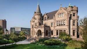 Een historisch gebouw met een opvallende toren en een boogvormige ingang.