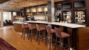 A modern bar area with a white countertop, bar stools, and shelves of liquor bottles. - Vacation Starts Here! Near Irvine Spectrum Center, Pets are Allowed Here (Laguna Hills)