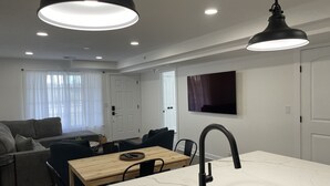 Una cocina moderna con encimera de mármol, grifo negro y luces colgantes.