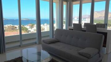 Relax in this stylish living room with expansive views of the coastal landscape and a comfortable sofa.