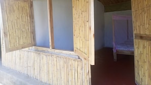 A room with bamboo walls and a bed with a canopy.