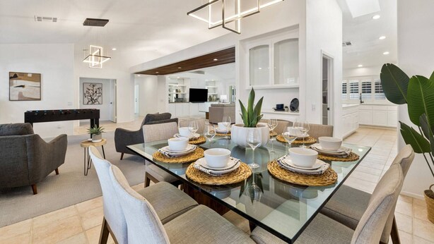 A modern dining area with a glass table set for six, surrounded by cushioned chairs. - Palm Desert Home w/Pool & Spa, Walk to Ironwood Park (Palm Desert)