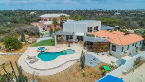 Propiedad residencial con piscina, patio y vista del paisaje circundante.
