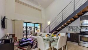 A modern apartment with a dining area, kitchen, and a staircase. - 2BR Duplex Palmaruba Condos w Great Location (Noord)