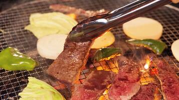 A grill with various meats and vegetables being cooked.