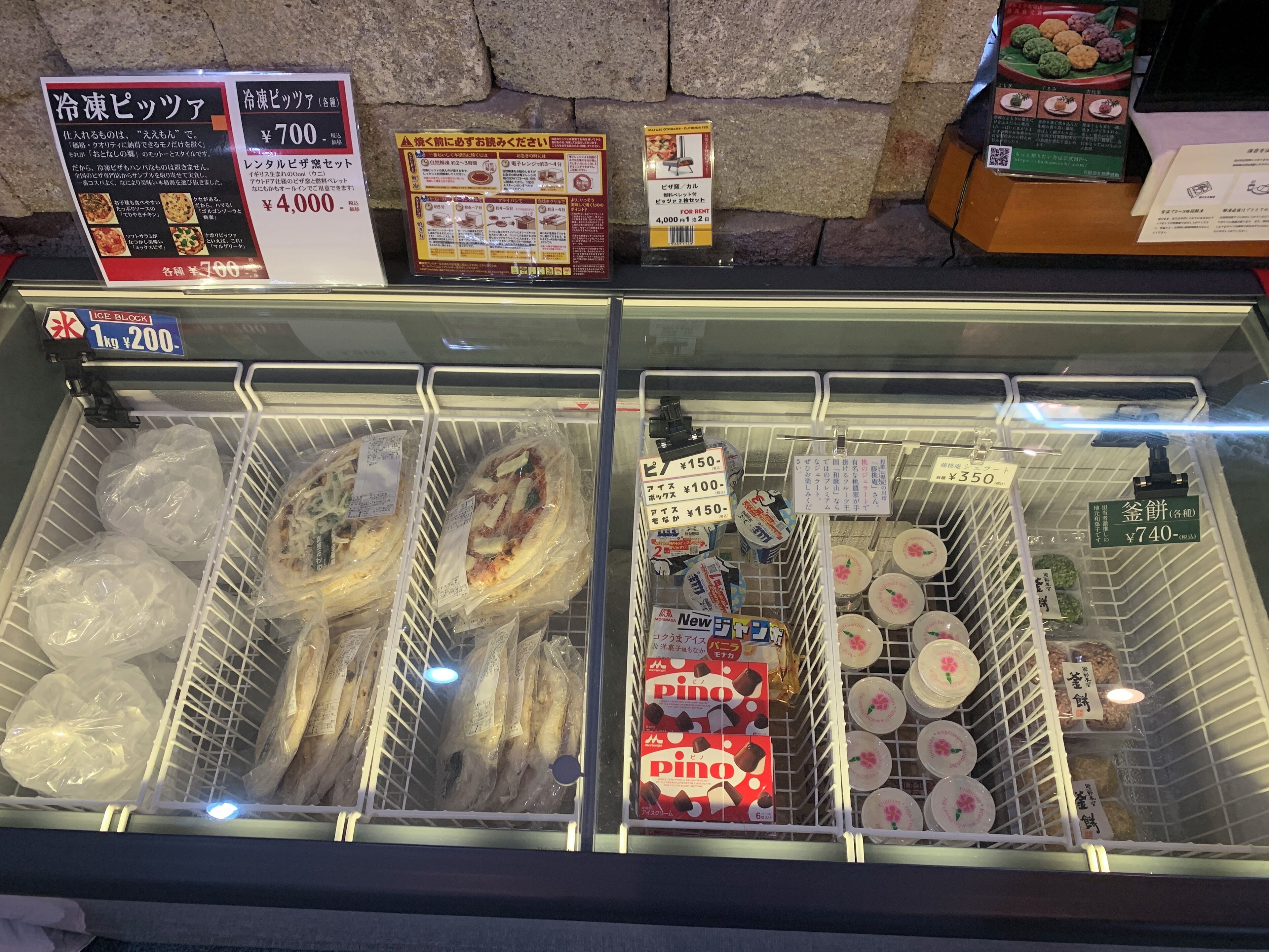A refrigerated display case with various packaged food items, including fish and packaged desserts.
