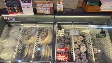A refrigerated display case with various packaged food items, including fish and packaged desserts.