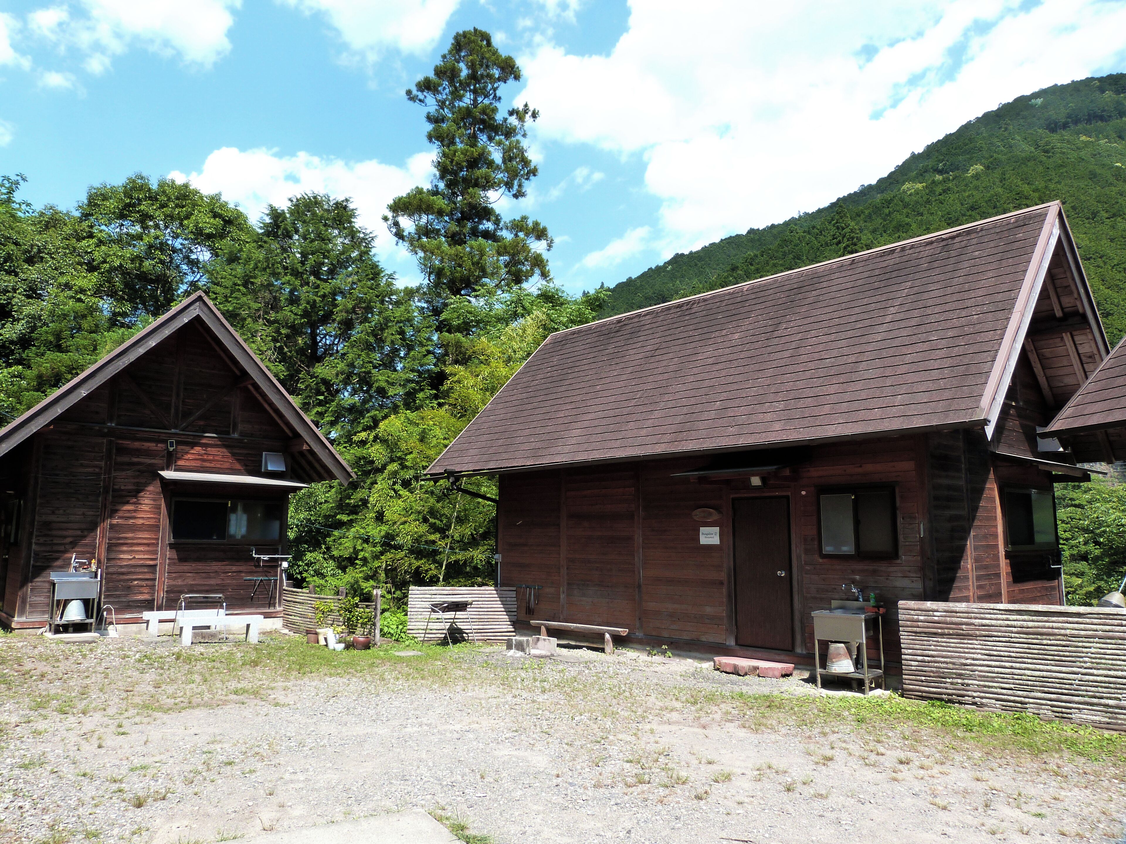 A rustic cabin with a sloped roof, a front porch, and a small front window.