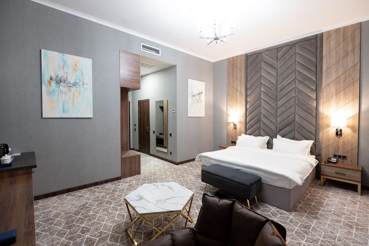 Una habitación de hotel moderna con una cama grande, un escritorio y una zona de estar.