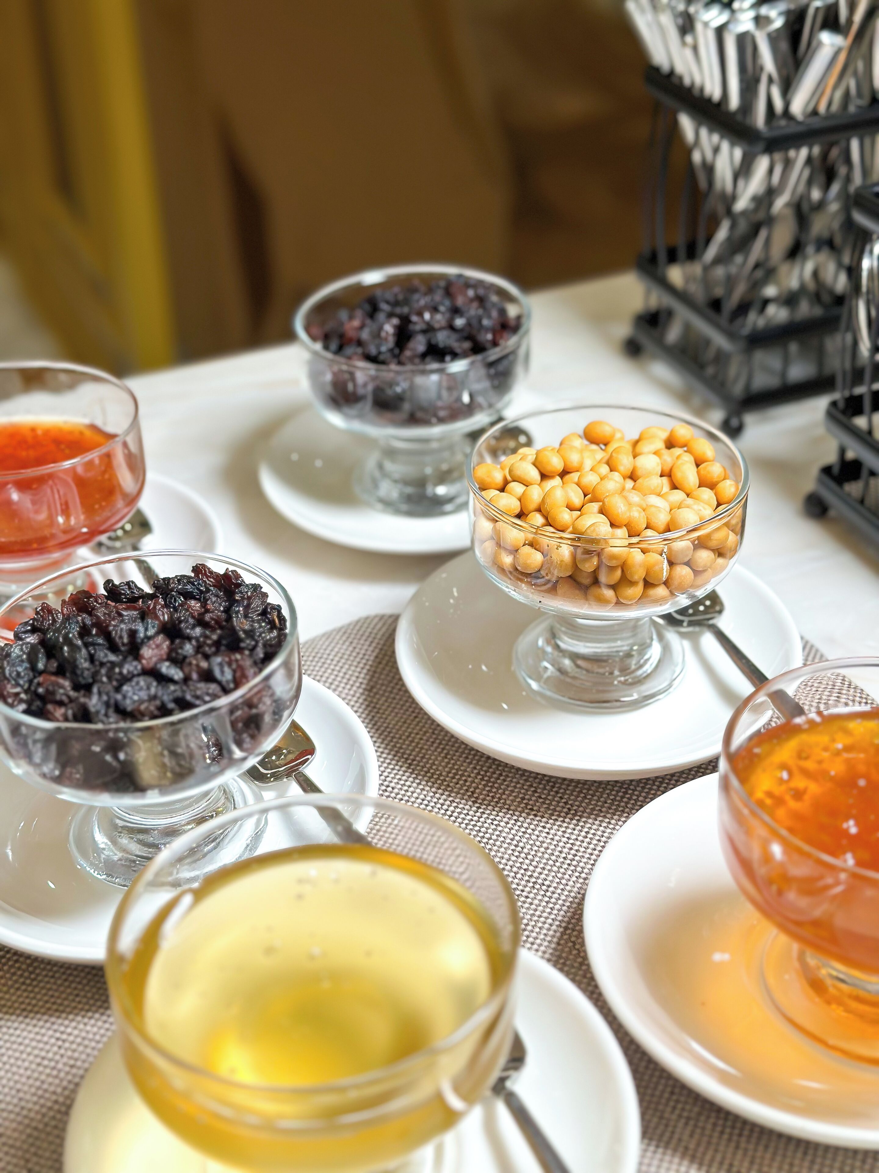 A table with various food items including bowls of chickpeas, dried fruits, and honey.