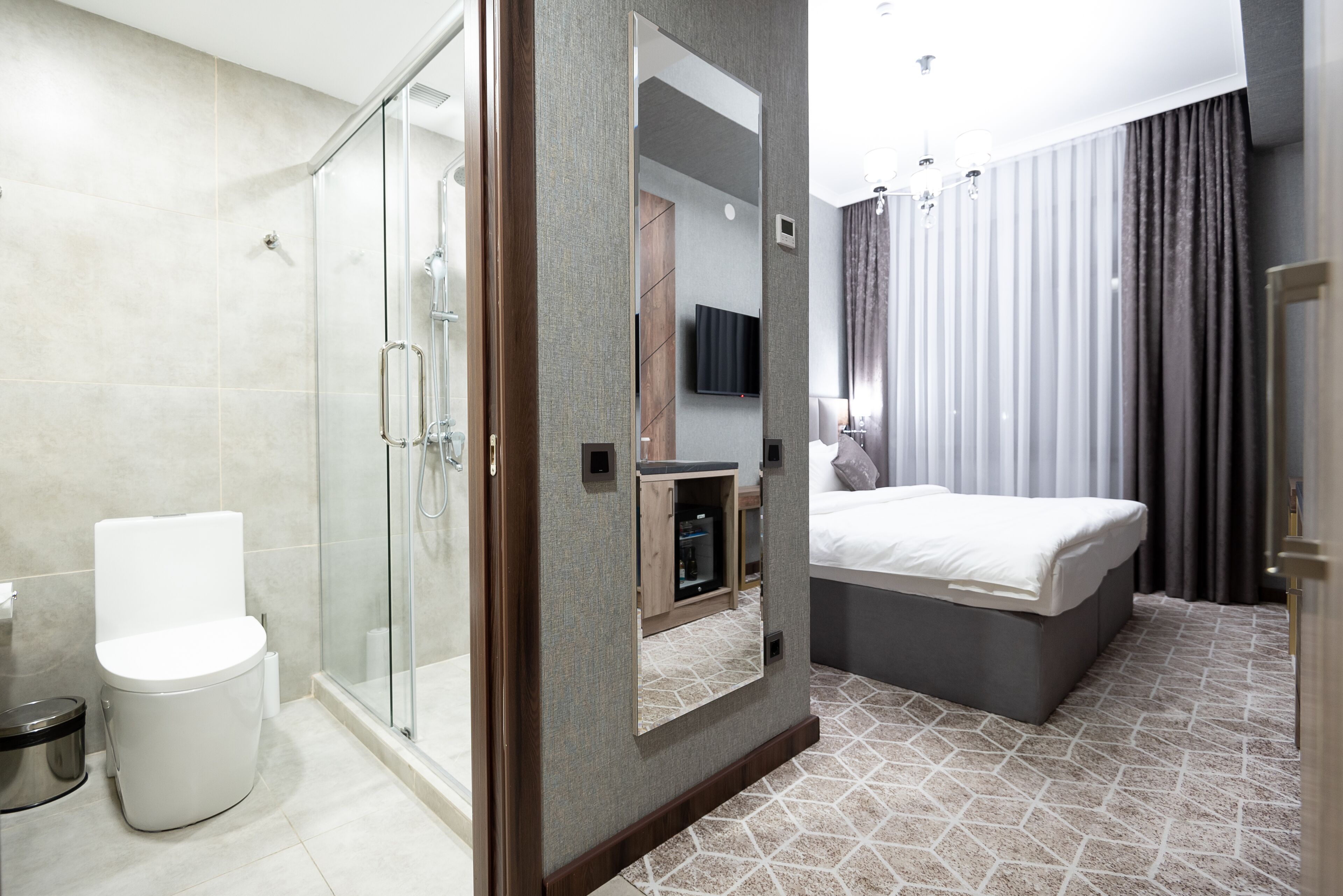 A modern bathroom with a glass shower enclosure, a toilet, and a sink.