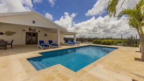 A modern pool area with a clear blue pool, sun loungers, and a covered patio. - Breathtaking Views 2br3ba Private Pool Large Space (Noord)