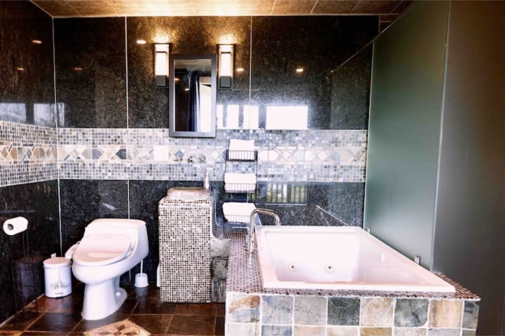 Une salle de bain moderne avec un lavabo en marbre, une baignoire sur pieds et des toilettes.