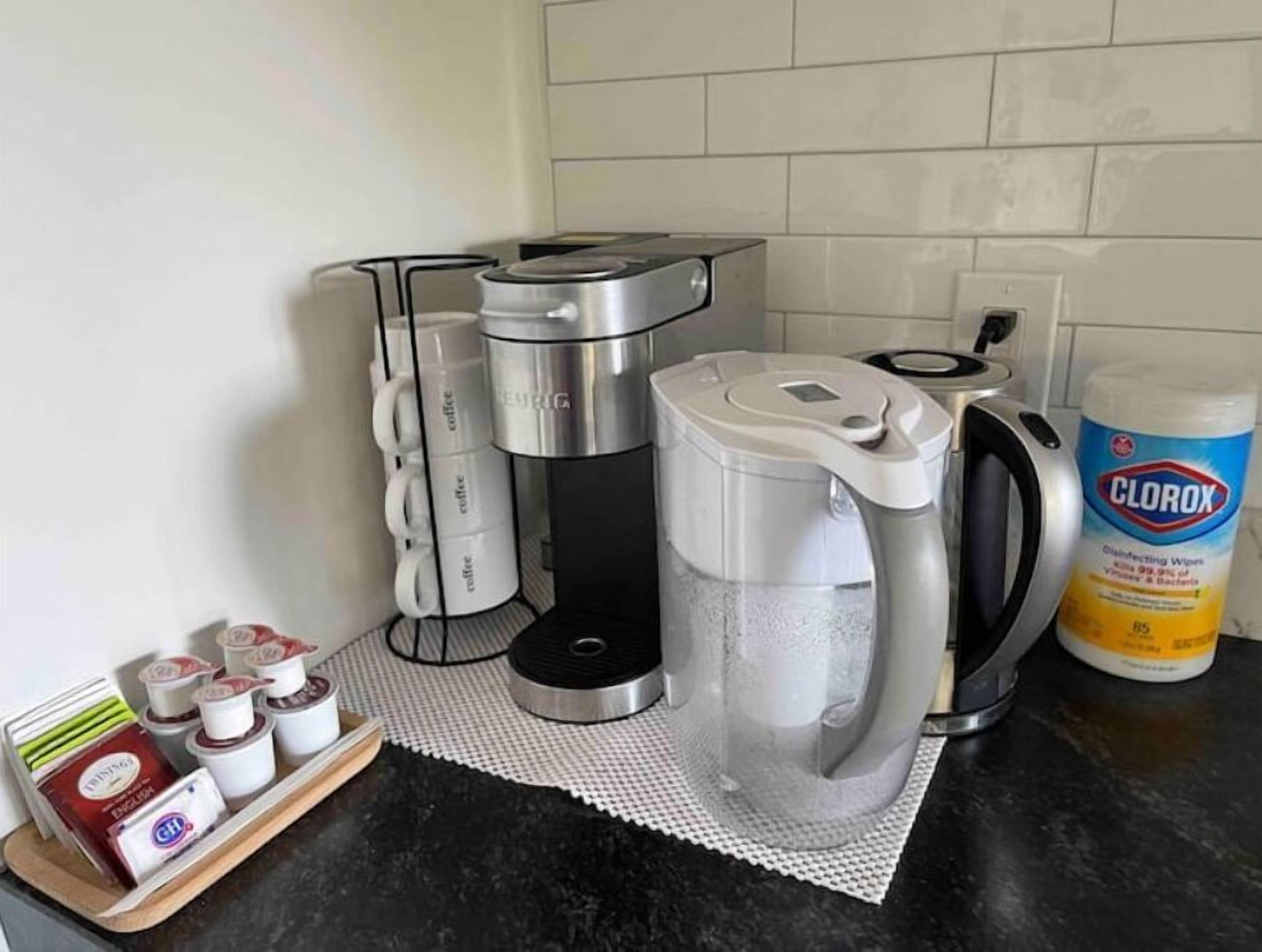 Una cocina con cafetera, hervidor y un envase de toallitas desinfectantes Clorox.