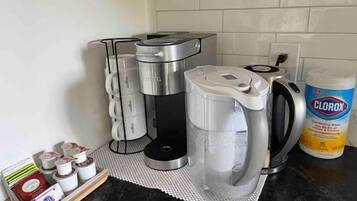 Una cocina con cafetera, hervidor y un envase de toallitas desinfectantes Clorox.