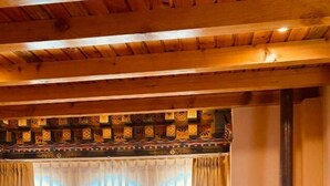 Una sala de estar acogedora con pisos de madera, un sofá, una mesa de centro y un estufa de leña.